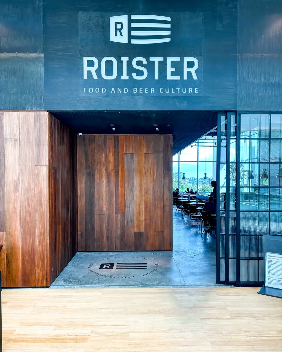 Entrada do Roister Barigüi, com o logo na parede